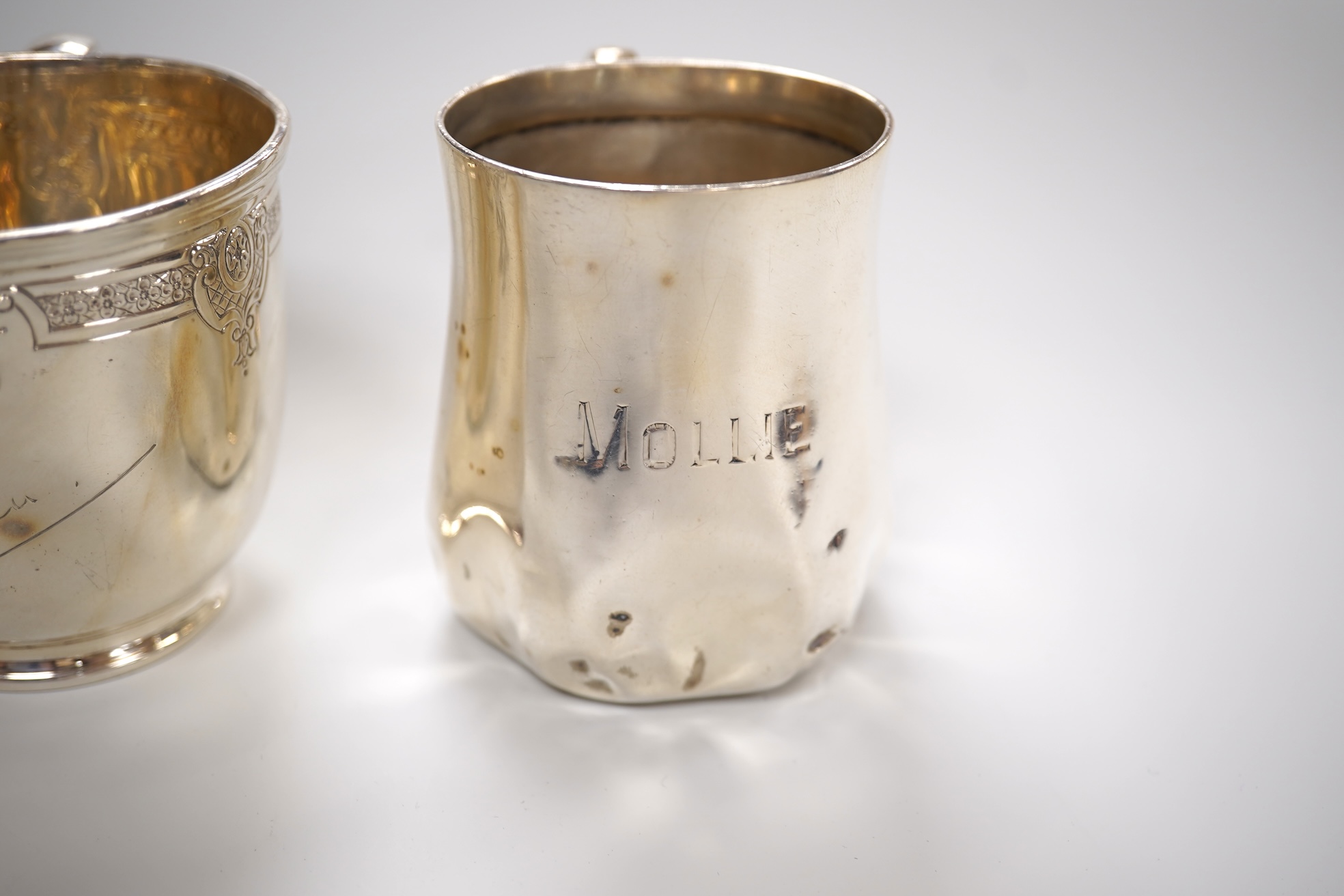 A George V engraved silver tea cup by Mappin & Webb, London, 1924, height 69mm, together with a Gorham sterling beaker and an Edwardian silver christening mug, 11oz.